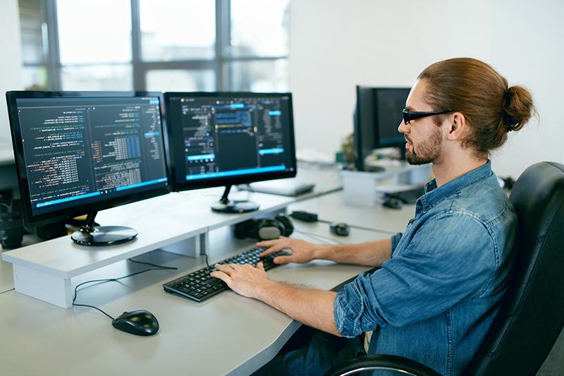 规划. 在计算机办公室工作的人，坐在办公桌前写代码. 程序员输入数据代码, 在软件开发公司做这个项目. 高质量的图像.